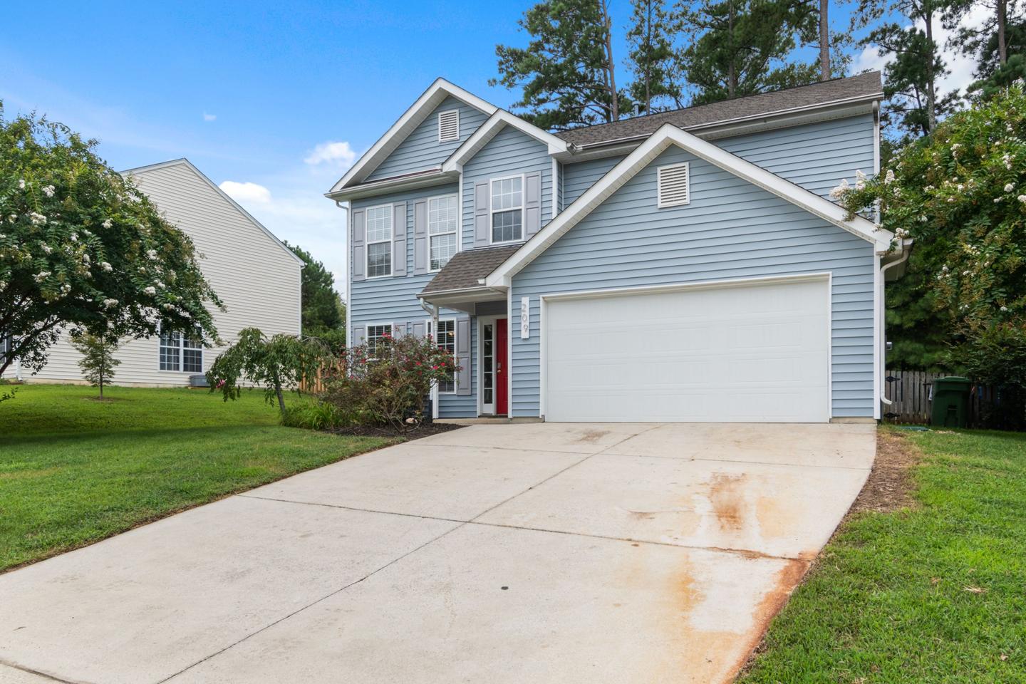 Two-story suburban home with blue siding and a white garage door, protected by home insurance